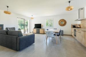 a living room with a couch and a table at Villa Bourdaines - Conciergerieland in Vielle-Saint-Girons