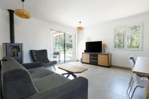 a living room with a couch and a tv at Villa Bourdaines - Conciergerieland in Vielle-Saint-Girons