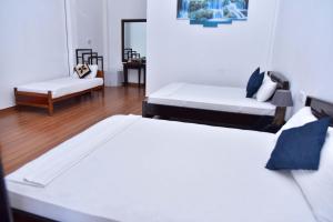a room with two beds and a couch in it at Hill Forest Cottage in Ella