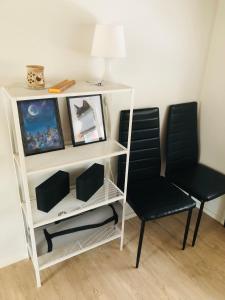 a white book shelf with two chairs and a lamp at The Zen Den Rokua in Utajärvi