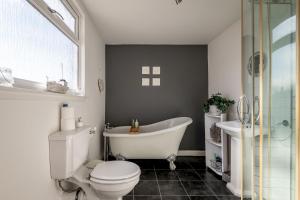 a bathroom with a tub and a toilet and a sink at Driftwood - Pittenweem in Pittenweem +25 photos