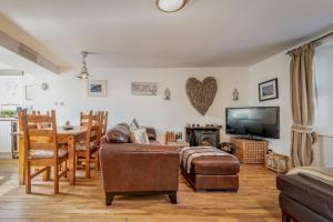 a living room with a couch and a flat screen tv at Driftwood - Pittenweem in Pittenweem