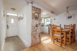 a kitchen and dining room with a stone wall at Driftwood - Pittenweem in Pittenweem