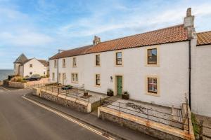 a white house on the side of a street at Driftwood - Pittenweem in Pittenweem
