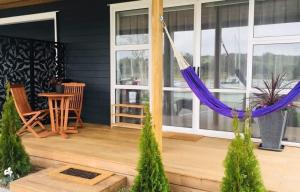 a porch with a hammock on a house at The Weiti Waterfront in Whangaparaoa