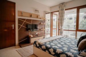 a bedroom with a bed and a tv and a window at LUHO Grande in Bangalore