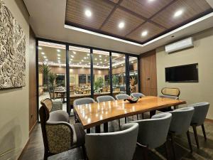 a conference room with a wooden table and chairs at Sima Hotel Kuta Lombok in Kuta Lombok
