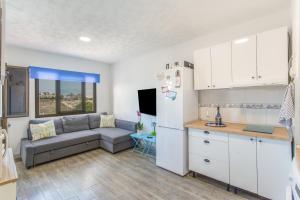 a living room with a couch and a kitchen at Rainbow Amadores in Mogán