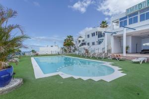a swimming pool in a yard next to a building at Rainbow Amadores in Mogán