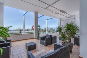 a patio with chairs and plants in a building at Rainbow Amadores in Mogán