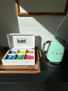 a box of different colored paints next to a tea kettle at La Maison Odeia Bordeaux Centre in Bordeaux