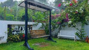 a gazebo with a bench in a garden at De Majestic Grand Villa in Auroville
