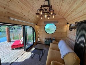 a living room in a tiny house with a couch at Scranton luxury fishing pod with private fishing Jetty in Spilsby