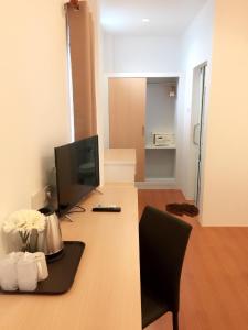 a room with a desk with a television and a chair at Nice Sea Resort in Srithanu