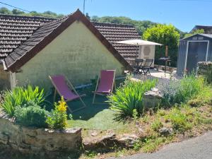 a cottage with purple chairs in the yard at La Maison du Druide in Bonneuil-en-Valois