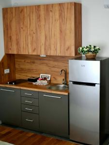 a kitchen with a stainless steel refrigerator and a sink at Orhideja 075 in Tuzla