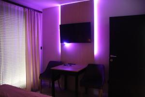 a room with a table with two chairs and a purple light at Palas rooms in Smederevska Palanka