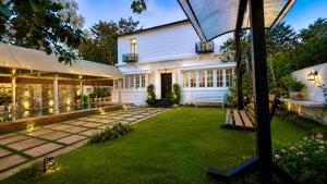a backyard with a white house with a lawn at De Majestic Grand Villa in Auroville