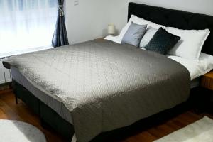 a bedroom with a large bed with pillows and a window at Orhideja 075 in Tuzla
