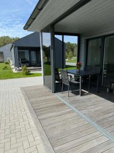 a deck with a table and chairs on a house at Navi Jūra House13 in Palanga