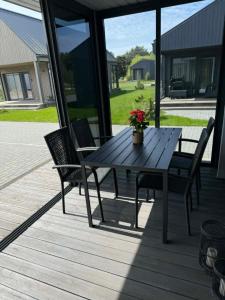 a wooden table and two chairs on a porch at Navi Jūra House13 in Palanga