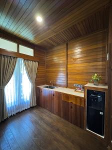 a kitchen with wooden walls and a sink and a window at Casa Kandara in Waingapu