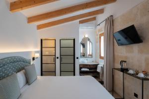 a bedroom with a white bed and a bathroom at Sa Pobla Rooms Ex Flor de Mandarina in Sa Pobla
