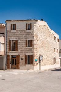 a large stone building on the corner of a street at Sa Pobla Rooms Ex Flor de Mandarina in Sa Pobla