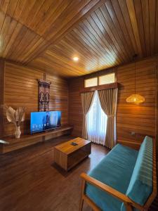 a living room with a bed and a tv at Casa Kandara in Waingapu