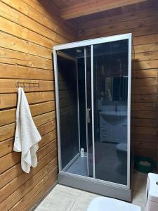 a bathroom with a glass shower in a wooden wall at Нур Срубы Сары Ой in Chon-Sary-Oy +11 photos