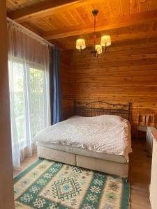 a bedroom with a bed in a log cabin at Нур Срубы Сары Ой in Chon-Sary-Oy