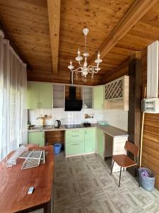 a kitchen with green cabinets and a wooden ceiling at Нур Срубы Сары Ой in Chon-Sary-Oy