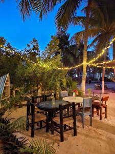 a table and chairs on the beach with lights at Beachfront Hacienda del Cuyo Groundfloor in El Cuyo