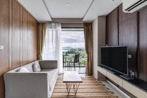 a living room with a couch and a flat screen tv at Panora Condo by Villacarte in Surin Beach