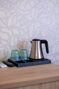 a tea kettle and two glasses on a table at Elit Garden Hotel in Kamianets-Podilskyi +9 photos