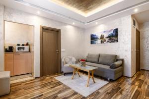 a living room with a couch and a table at One Luxury Suites AKUSTIK - 3 minuta peške do Jezera in Zlatibor