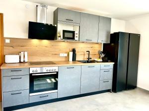 a kitchen with stainless steel appliances and a black refrigerator at Gästehaus Trockau in Pegnitz +27 photos