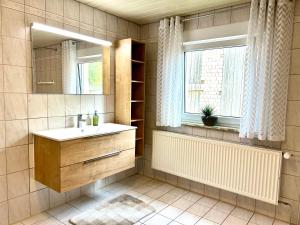a bathroom with a sink and a mirror and a window at Gästehaus Trockau in Pegnitz