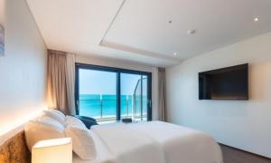 a bedroom with a large bed and a large window at Hotel GITE in Siheung