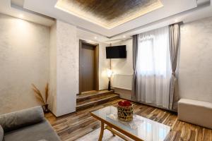a living room with a couch and a table at One Luxury Suites AKUSTIK - 3 minuta peške do Jezera in Zlatibor