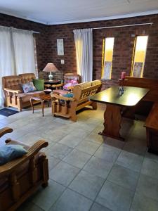 a living room with couches and a table and chairs at Siësta Guesthouse in Modimolle