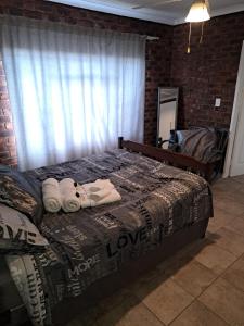 a bedroom with a bed with towels on it at Siësta Guesthouse in Modimolle