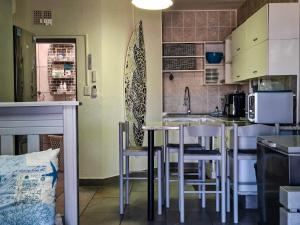 a kitchen with a table and chairs and a counter at Eden Dunes 75B in Shelly Beach +8 photos