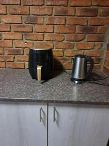 a black coffee pot and a candle on a counter at Siësta Guesthouse in Modimolle