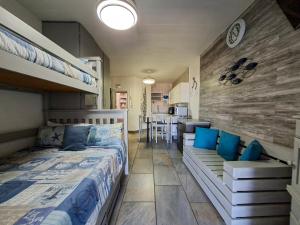 a bedroom with a bunk bed and a kitchen at Eden Dunes 75B in Shelly Beach