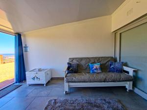 a couch sitting in a living room with a window at Eden Dunes 75B in Shelly Beach