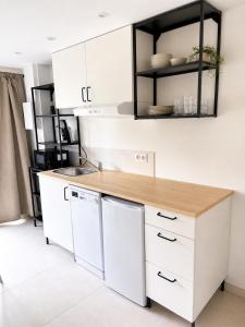 a kitchen with white cabinets and a wooden counter top at Petit Castel in Châteaubriant