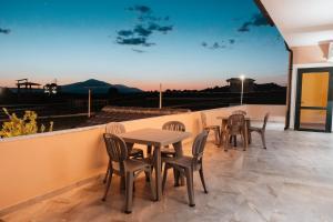 a patio with tables and chairs on a balcony at Matteo Garden & Restaurant in Vlorë