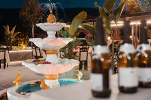 a fountain on a table with bottles of beer at Matteo Garden & Restaurant in Vlorë