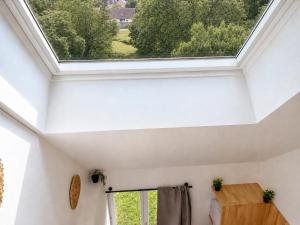 a skylight in a white room with a window at Petit Castel in Châteaubriant +3 photos